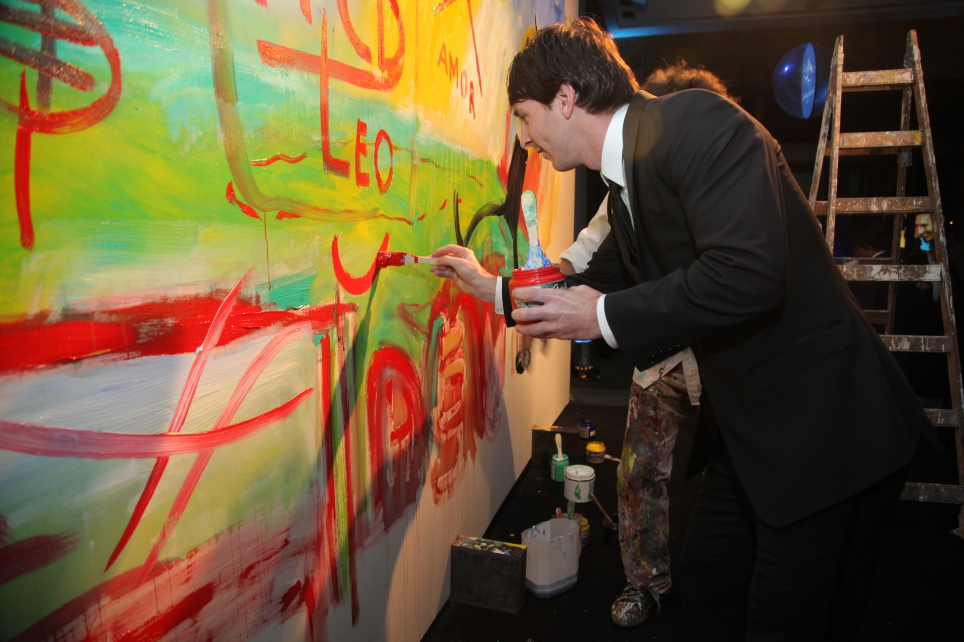 Leo Messi painting alongside the campaign artwork during the 2010 solidarity gala.