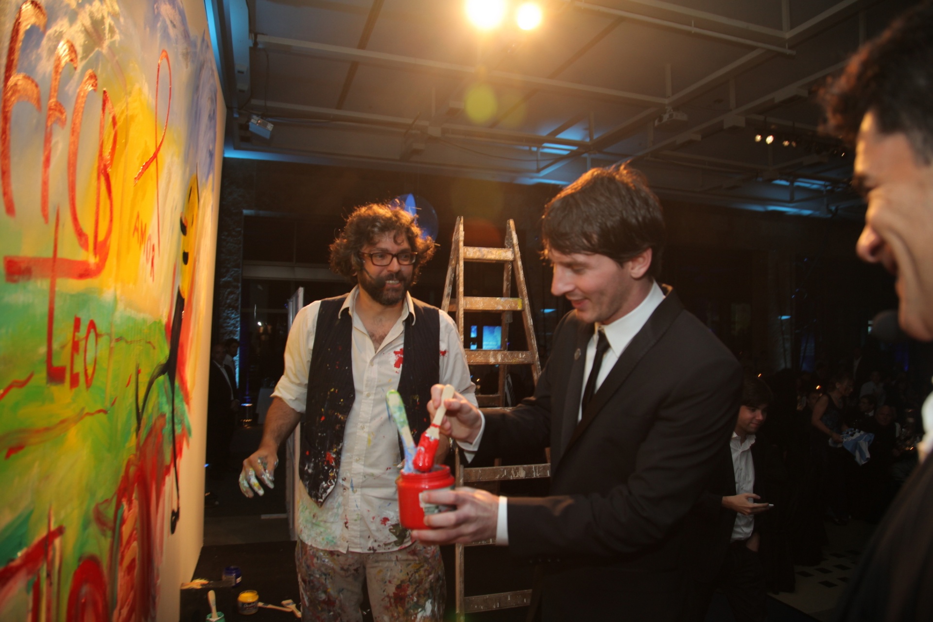 A candid moment with Messi, Liniers, and the painted canvas during the gala.